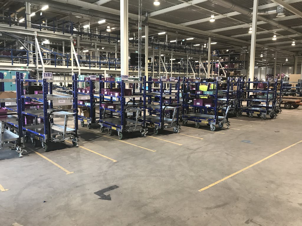 Pre-kitted parts trolley next to an assembly line